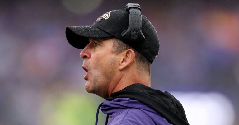 a man wearing a hat and a purple jacket