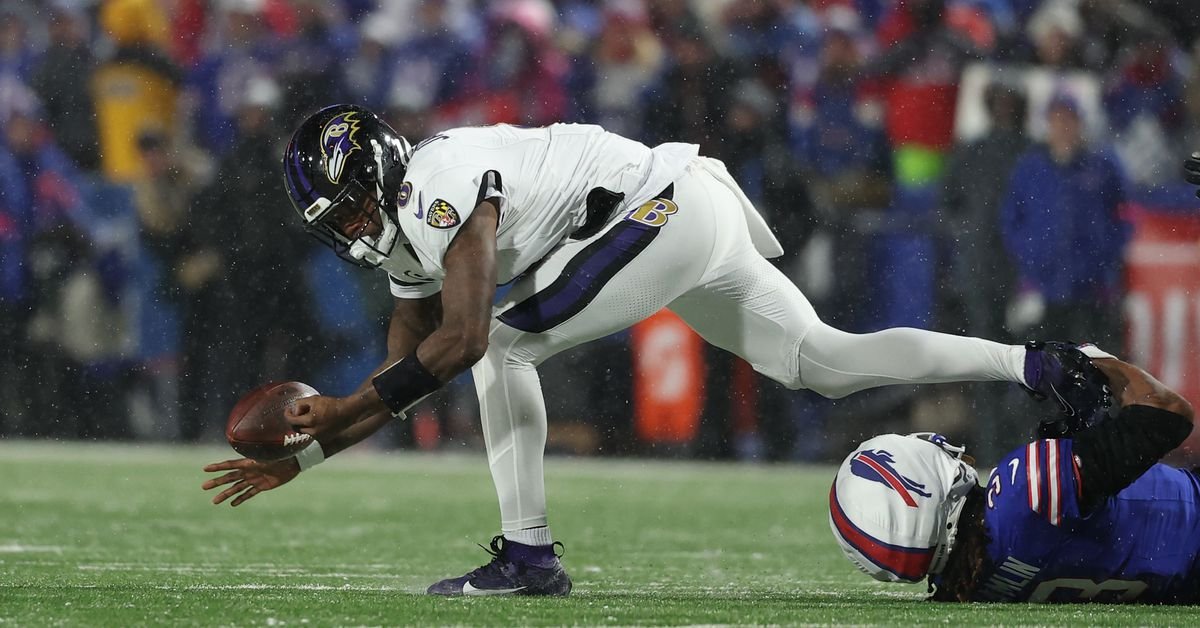 a football player falling down to catch a football