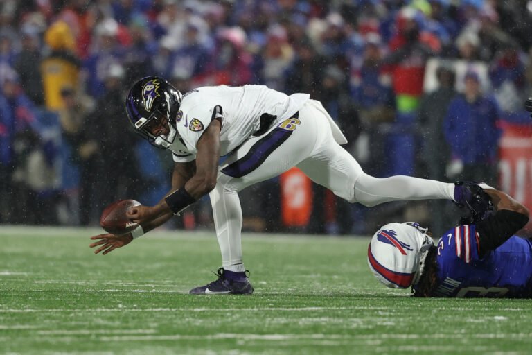 a football player falling down to catch a football