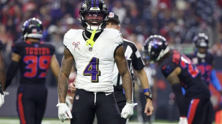 a football player laughing with other players in the background