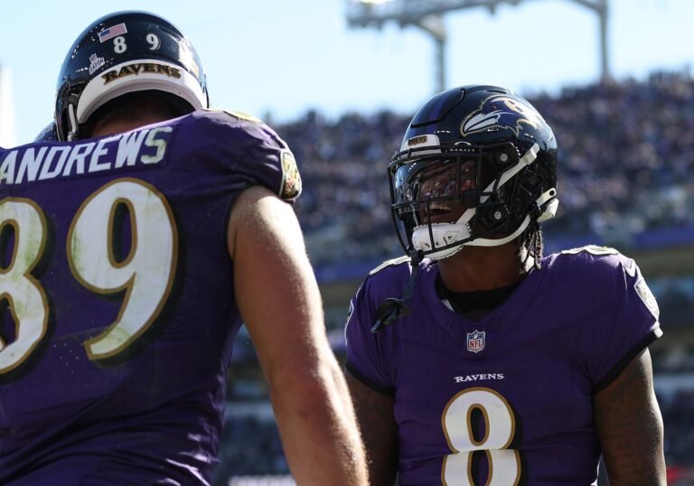 two football players in purple uniforms