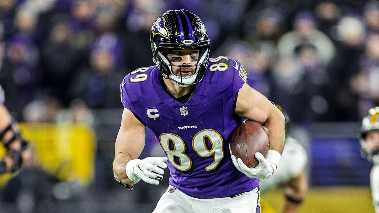 a football player in a purple uniform holding a football