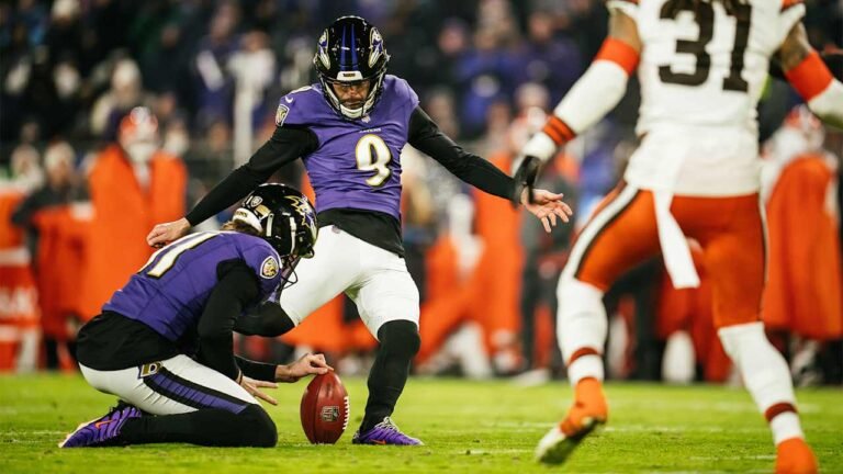 a football player in a purple uniform with a football in the background