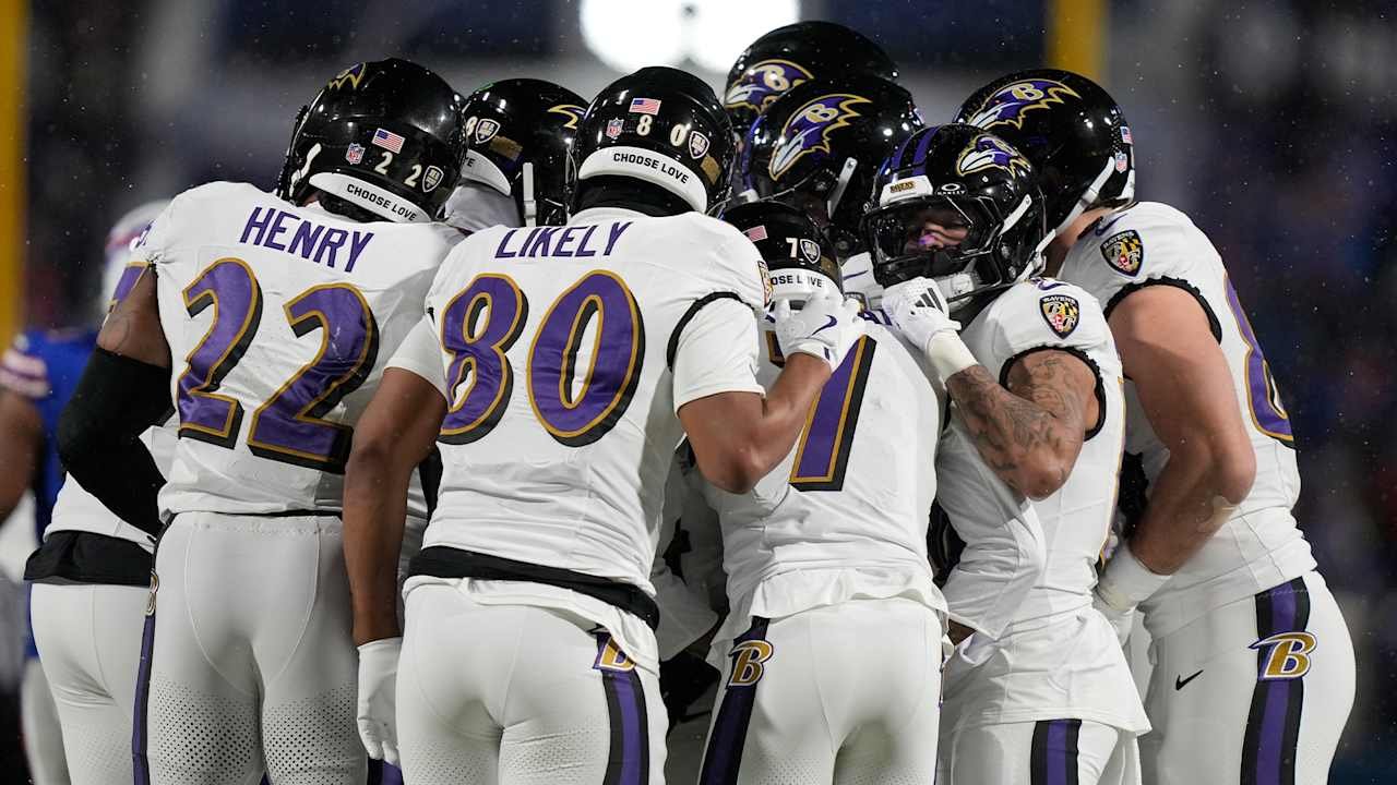 a group of football players huddle