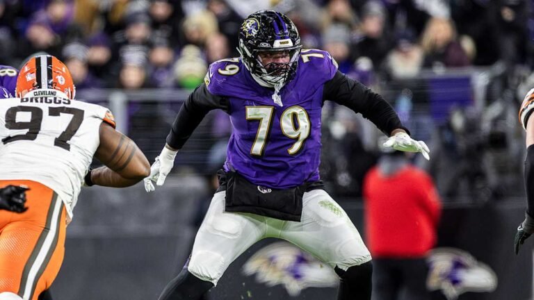 a football player in a purple uniform with a football in the back
